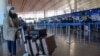 Seorang penumpang tiba di Bandara Internasional Beijing untuk melakukan check in pada 29 Desember 2022. (Foto: AP/Andy Wong)