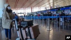 Seorang penumpang tiba di Bandara Internasional Beijing untuk melakukan check in pada 29 Desember 2022. (Foto: AP/Andy Wong)