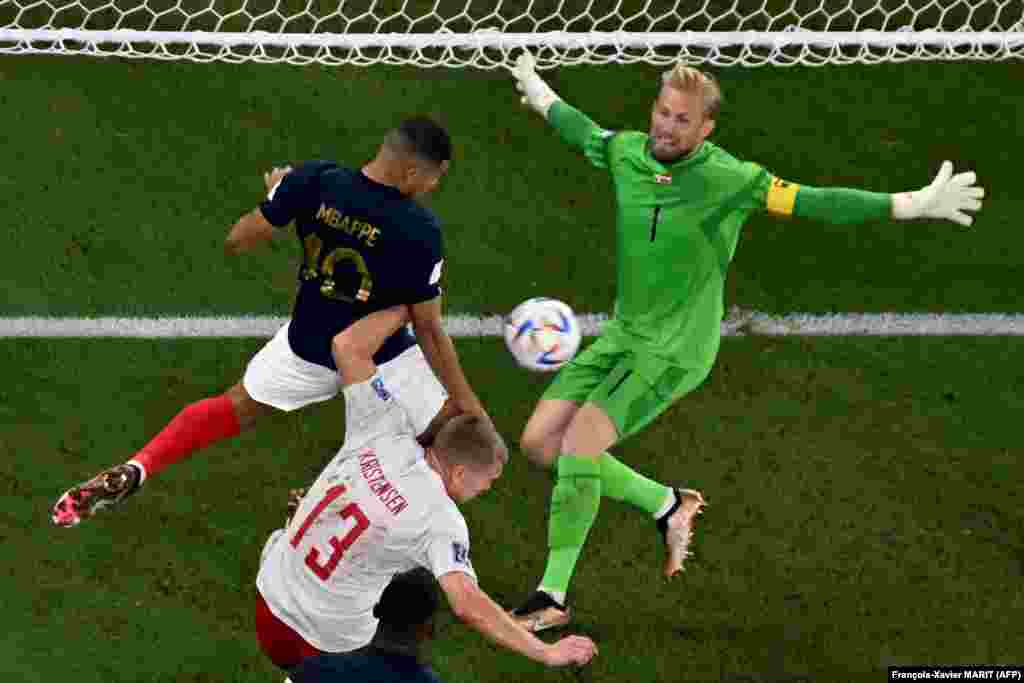 Kasper Schmeichel, guarda-redes da Dinamarca não consegue parar Kylian Mbappé enquanto este marca o segundo golo da França. Stadium 974, Doha. Nov 26