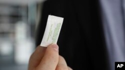 FILE - Patrick Flynn, a co-founder of Hazel Technologies, holds a sachet designed to slow the ripening of process of various fruits, Oct. 24, 2022, in Chicago.