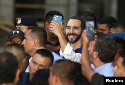 FILE - El Salvador's President Nayib Bukele smiles while someone takes a picture of him during an event, in Nahuizalco, El Salvador, Sept. 7, 2022.