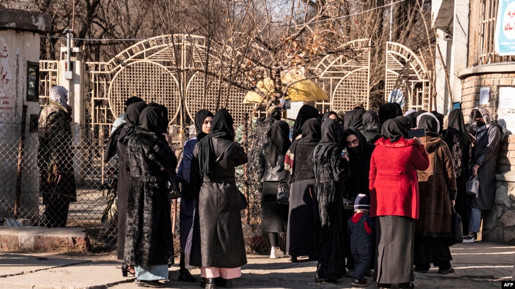 Afghan female university students are stopped by Taliban security personnel next to a university in Kabul, Dec. 21, 2022.
