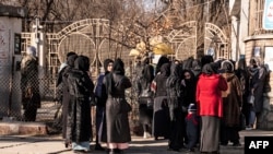 Afghan female university students are stopped by Taliban security personnel next to a university in Kabul, Dec. 21, 2022.