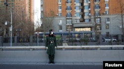 A member of the Chinese People's Armed Police Force wears a face mask as he keeps watch on a street amid coronavirus disease (COVID-19) outbreaks in Beijing, Dec. 1, 2022. 