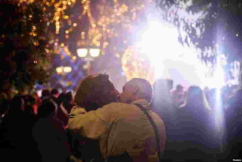 Una pareja se besa durante el encendido de luces de un árbol de Navidad en Atenas, Grecia. &nbsp;