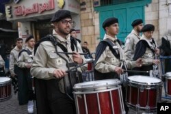 Palestinian scouts march during a Christmas parade toward the Church of the Nativity, traditionally believed to be the birthplace of Jesus Christ, in the West Bank town of Bethlehem, Dec. 24, 2022.