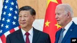 FILE - U.S. President Joe Biden, right, stands with Chinese President Xi Jinping before a meeting on the sidelines of the G-20 summit meeting, in Bali, Indonesia, Nov. 14, 2022. 