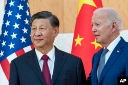 FILE - U.S. President Joe Biden, right, stands with Chinese President Xi Jinping before a meeting on the sidelines of the G-20 summit meeting, in Bali, Indonesia, Nov. 14, 2022.