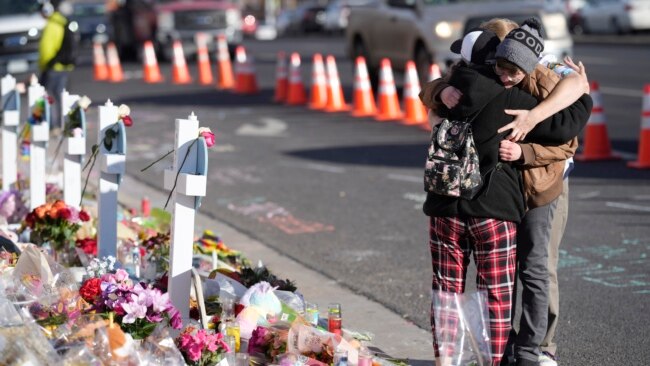 FILE - Visitors hug near the scene of a mass shooting at a gay nightclub in Colorado Springs, Colorado, on Nov. 23, 2022. The U.S. is in “a heightened threat environment” because of lone offenders and small groups, according to the new National Terrorism Advisory System bulletin.