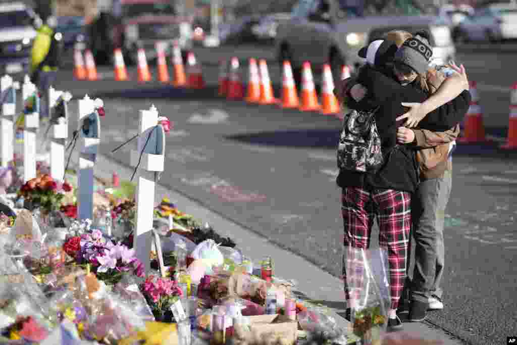 Visitors hug at a makeshift memorial near the scene of a mass shooting at a gay nightclub in Colorado Springs, Colorado.