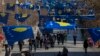 FILE - Kosovo's flags fly in Pristina as police officers patrol during a celebration of the country's independence, Feb. 17, 2020.