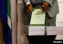 FILE - A person unwraps the report ahead of handing it over to the speaker of parliament on whether South African president Cyril Ramaphosa should face an impeachment inquiry over the Phala Phala saga in Cape Town, South Africa, Nov. 30, 2022.