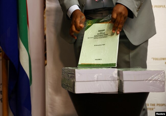 A person unwraps the report ahead of handing it over to the speaker of parliament on whether South African president Cyril Ramaphosa should face an impeachment inquiry over the Phala Phala saga in Cape Town, South Africa, Nov. 30, 2022.