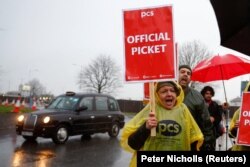 Anggota Serikat Layanan Publik dan Komersial (PCS) ikut serta dalam aksi pemogokan pasukan perbatasan di dekat Bandara Heathrow, di London, Inggris 23 Desember 2022. (Foto: REUTERS/Peter Nicholls)