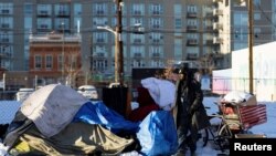 A man stands outside of a tent in the city of Denver, Colorado, in the United States, Dec. 22, 2022. City officials and outreach workers across the U.S. were rushing to get people off the streets and indoors during harsh winter conditions in December, 2022.