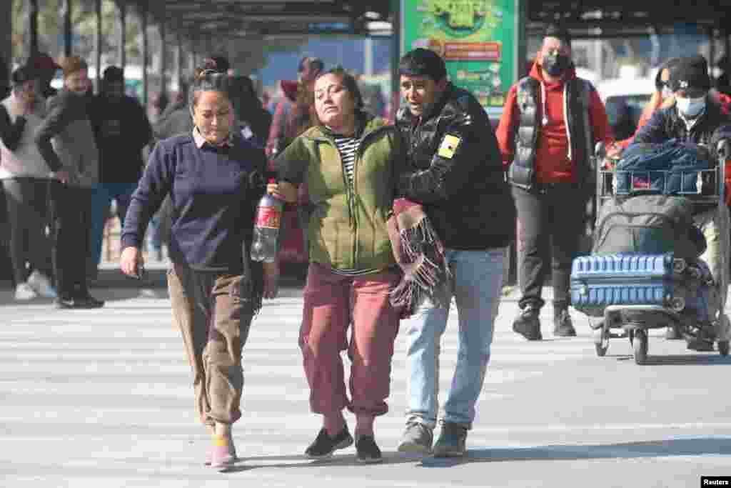 Член на семејството на жртвата на авионот што се урна во Похара е придружуван додека тагува на аеродромот во Катманду, Непал.