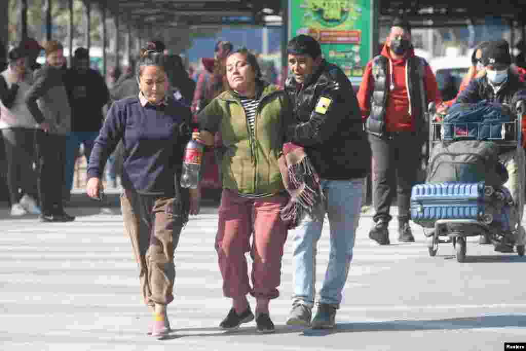 A family member of a victim of the aircraft that crashed in Pokhara is escorted as she mourns at the airport in Kathmandu, Nepal.