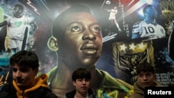 FILE: People stand in front of a mural of football legend Pele in New York City's Times Square. taken December 30, 2022.