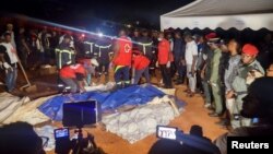 Rescuers prepare to carry a body after a landslide which killed people who were attending a funeral, in Yaounde, Cameroon, Nov. 27, 2022.