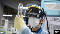 An employee conducts a tritium measurement on a sample of contaminated water at the Tokyo Electric Power Company Fukushima Dai-ichi nuclear power plant in Okuma, Japan, March 5, 2022.