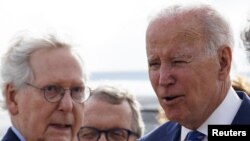 U.S. President Joe Biden is greeted by Senate Republican Leader Mitch McConnell (R-KY) and Ohio Governor Mike DeWine as he arrives at Cincinnati Northern Kentucky Airport in Hebron, Kentucky, U.S., January 4, 2023.
