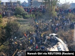 Warga berkumpul setelah kecelakaan pesawat di Pokhara, Nepal 15 Januari 2023 dalam gambar ini diperoleh dari media sosial. (Foto: Naresh Giri via REUTERS)