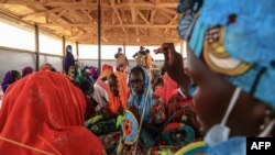 A group of women make fans in a workshop given by members of the NGO, Plan International, during a visit by Filippo Grandi, the United Nations High Commissioner for Refugees (UNHCR), in Maroua, Cameroon on April 28, 2022. 
