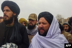 Taliban official members look on during the public flogging of women and men at a football stadium in Charikar city of Parwan province, Dec. 8, 2022.