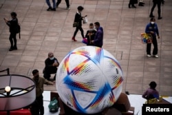 上海民众观看2022卡塔尔世界杯比赛用球模型。（2022年11月23日）