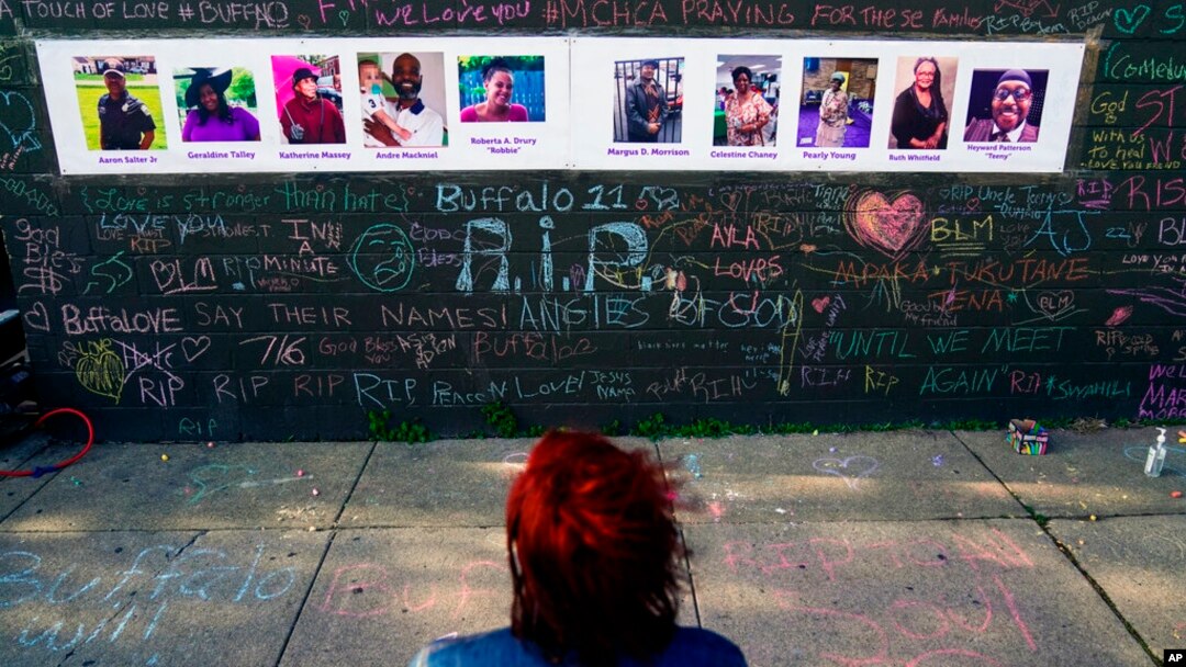FILE - A person visits a makeshift memorial near the scene of a shooting targeting Black people at a supermarket, in Buffalo, on May 19, 2022.