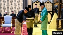 Malaysia's King Sultan Abdullah Sultan Ahmad Shah and Malaysia's newly appointed Prime Minister Anwar Ibrahim take part in the swearing-in ceremony at the National Palace in Kuala Lumpur, Nov. 24, 2022.