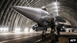 A Rafale jet fighter pilot checks and prepares his aircraft before leaving for a four-month mission to protect the airspace of the Baltic States, in Mont-de-Marsan, southwestern France.