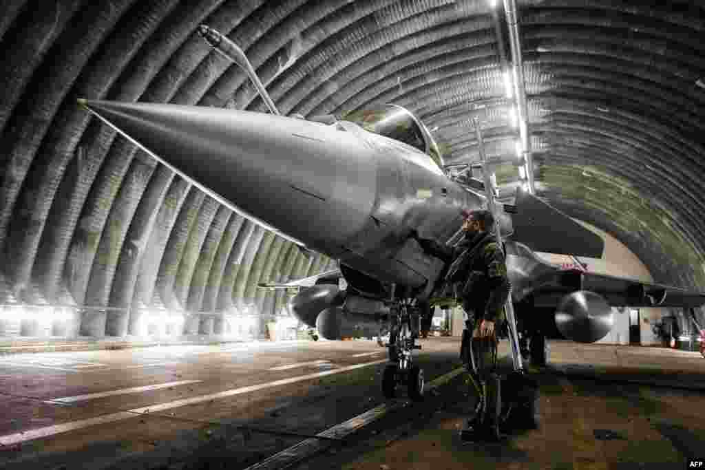 A Rafale jet fighter pilot checks and prepares his aircraft before leaving for a four-month mission to protect the airspace of the Baltic States, in Mont-de-Marsan, southwestern France.