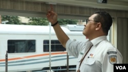 Juru Bicara KAI Pariwisata, Ilud Siregar menunjukkan tombol pengatur buka tutup tirai untuk jendela di Kereta Panoramic. (VOA/Indra Yoga)