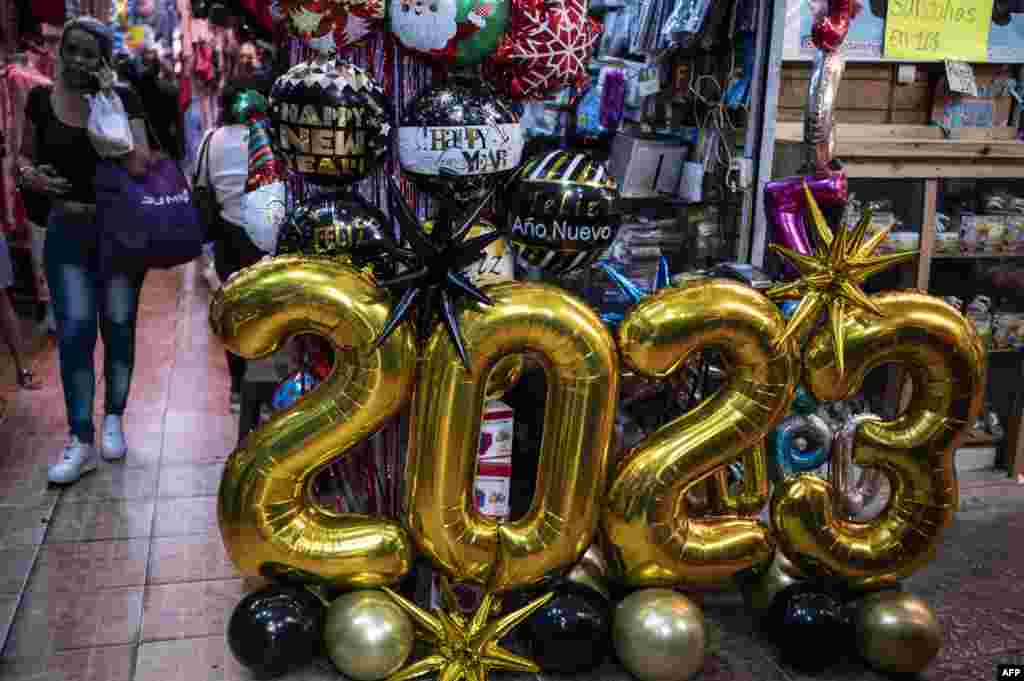 Globos y letreros de 2023 adornan el mercado de San Jacinto en el centro histórico de Caracas el 30 de diciembre de 2022, en la víspera de las celebraciones de fin de año. (Foto de Yuri CORTEZ / AFP)