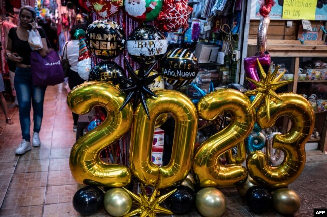 Globos y letreros de 2023 adornan el mercado de San Jacinto en el centro histórico de Caracas el 30 de diciembre de 2022, en la víspera de las celebraciones de fin de año. (Foto de Yuri CORTEZ / AFP)