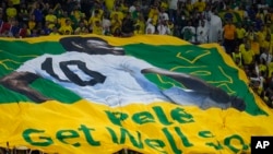 Brazilian fans hold a banner showing the Brazilian soccer legend Pele with the message 'Get well soon' during the World Cup round of 16 soccer match between Brazil and South Korea, at the 974 Stadium, in Doha, Qatar, Dec. 5, 2022.