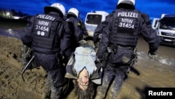 Police officers carry a demonstrator during a protest against the expansion of a coal mine in Luetzerath, Germany, Jan. 14, 2023.