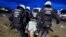 Para petugas kepolisian tampak membawa seorang demonstran yang memprotes perluasan wilayah tambang batu bara di Luetzerath, Jerman, pada 14 Januari 2023. (Foto: Reuters/Wolfgang Rattay)