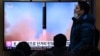 Warga menonton layar televisi yang menayangkan siaran berita uji coba rudal Korea Utara, di stasiun kereta api di Seoul, Korsel, 23 Desember 2022 (Jung Yeon-je / AFP)