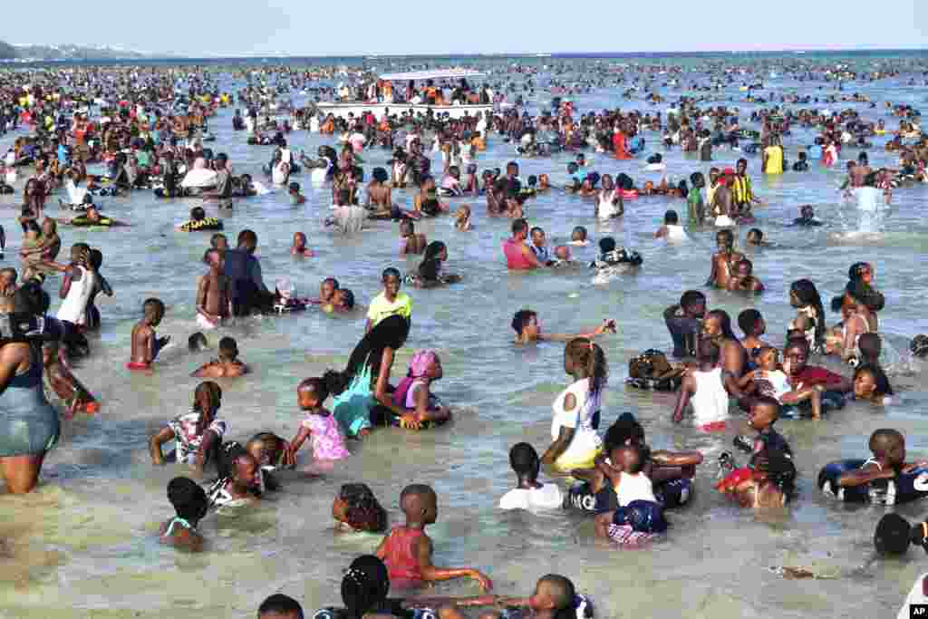 Ratusan wisatawan sedang berlibur di Pantai Umum Jomo Kenyatta setelah menghadiri kebaktian gereja di berbagai gereja di kota Mombasa, Kenya, Minggu, 25 Desember 2022. (Foto: AP/Gideon Maundu)