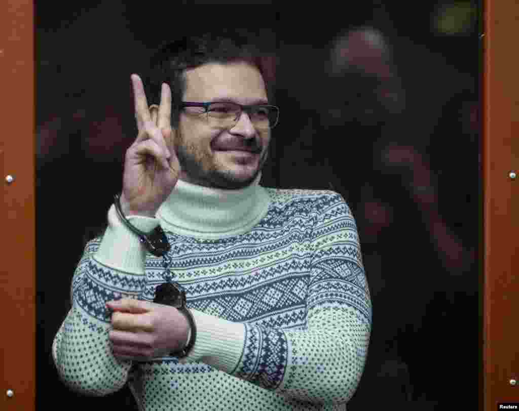 Russian opposition leader, Moscow's former municipal deputy Ilya Yashin, gestures in a defendants' glass cage prior to a verdict hearing at the Meshchansky district court in Moscow, Russia.