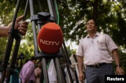 FILE - A microphone of New Delhi Television (NDTV) is placed on a tripod along a roadside in New Delhi, India, Aug. 26, 2022.