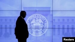 Un guardia de seguridad camina frente a una imagen de la Reserva Federal después de la reunión de política del Comité Federal de Mercado Abierto (FOMC) de dos días en Washington, el 16 de marzo de 2016.