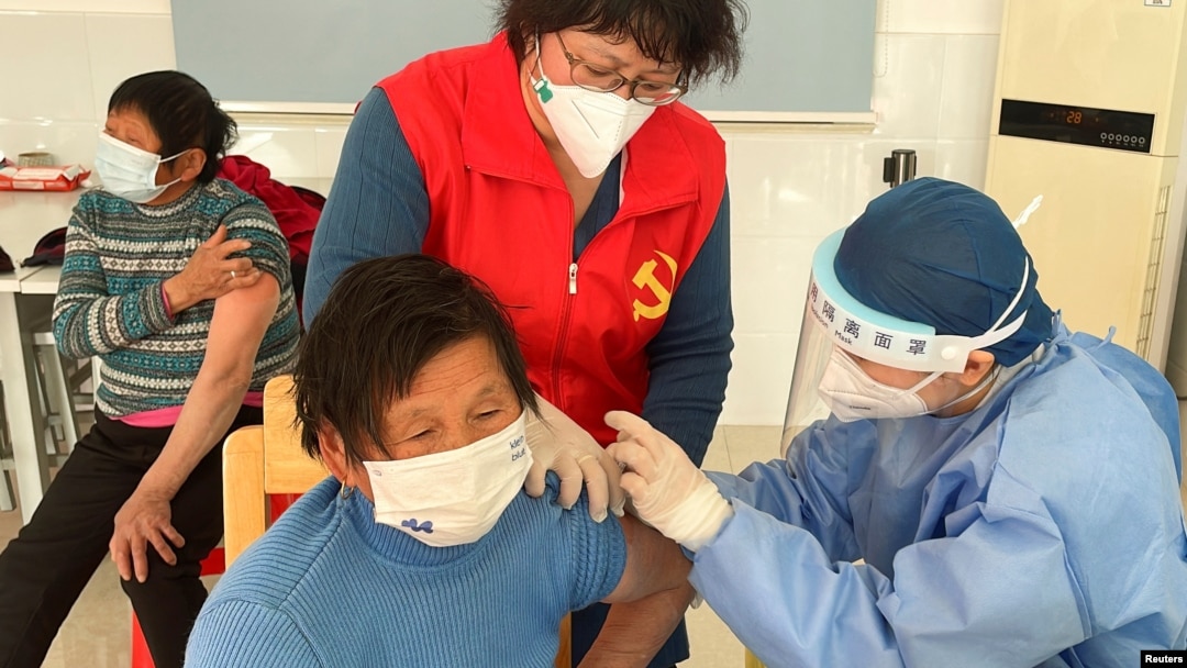 Một nhân viên y tế tiêm vắc-xin COVID-19 cho một người cao tuổi, trong chuyến thăm do chính phủ tổ chức tới một trung tâm tiêm chủng ở làng Zhongmin, ngoại ô Thượng Hải, ngày 21 tháng 12 năm 2022.