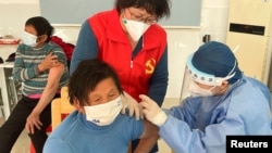 中国医护人员在上海郊区的村庄里为老年人接种新冠疫苗。（2022年12月21日）