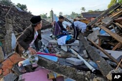 Warga mencari barang layak pakai dari rumahnya yang hancur akibat gempa yang menghantam Cianjur, Jawa Barat, Kamis, 24 November 2022. (Foto: AP/Tatan Syuflana)