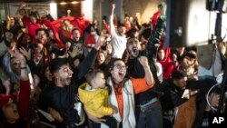 Moroccans in Rabat, Morocco, celebrate after the goalkeeper Yassine Bounou saved a penalty during their win against Spain in a World Cup match played in Qatar, Dec. 6, 2022. 