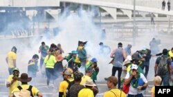 Los partidarios del expresidente brasileño Jair Bolsonaro chocan con la policía durante una manifestación frente al Palacio Planalto en Brasilia el 8 de enero de 2023. [Foto: AFP]
