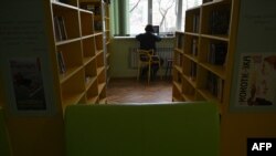 A man works with his laptop in a public library in Irpin, northwest of Kyiv, on Dec. 23, 2022, amid the Russian invasion of Ukraine.